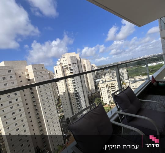 מרפסת עם נוף לבניינים ושמים כחולים